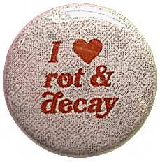 A circle pin with a white noise background and red serif text that says: I [heart] rot & decay.